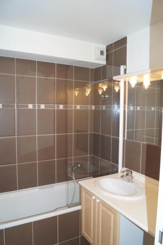 une salle de bain avec un lavabo, une douche et une baignoire dans l'établissement Bel appart T2, 3 étoiles, avec balcon bien exposé, à Vielle-Aure
