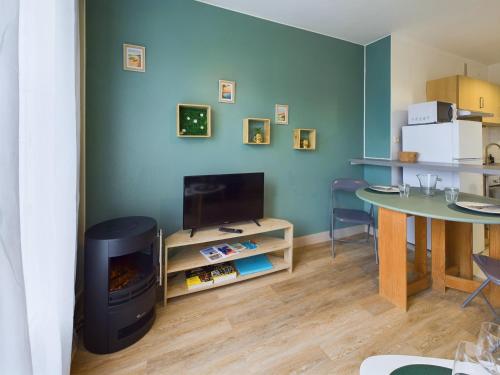 un salon avec une cheminée et une table dans l'établissement À 110 m de la plage, appartement moderne pour 4, à Fouesnant