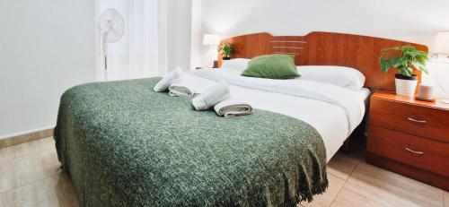 a bedroom with two beds and a green blanket at Apto Familiar en Alicante, 4 Pax, 3 Camas, 2 Baños in Elche