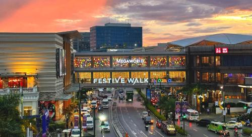 eine belebte Stadtstraße mit Verkehr vor einem Gebäude in der Unterkunft The Palladium Iloilo near Convention Center Studio unit with private balcony City View studio only in Iloilo City