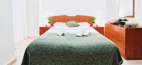 a bedroom with a large bed with a green blanket at Apto Familiar en Alicante, 4 Pax, 3 Camas, 2 Baños in Elche