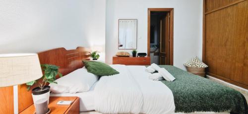 a bedroom with a large white bed with a green blanket at Apto Familiar en Alicante, 4 Pax, 3 Camas, 2 Baños in Elche