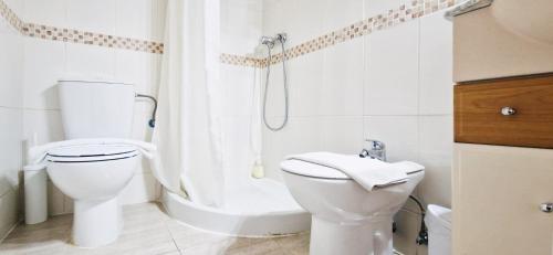 a white bathroom with a toilet and a shower at Apto Familiar en Alicante, 4 Pax, 3 Camas, 2 Baños in Elche