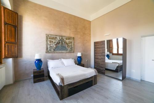a bedroom with a large bed and a mirror at Al Console Le Dimore Apartment in Monopoli