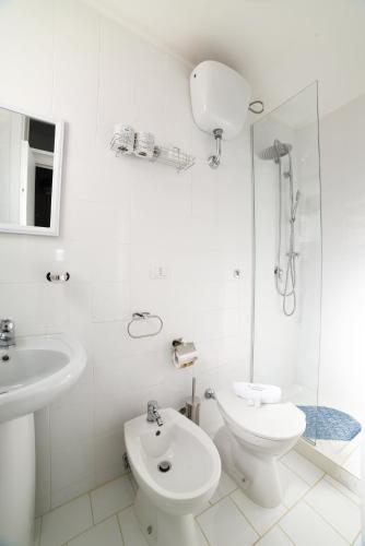 a white bathroom with a toilet and a sink at Al Console Le Dimore Apartment in Monopoli