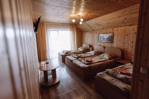 a room with three beds and a table in it at Highland in Yablunytsya