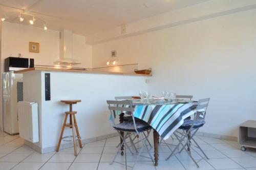 une cuisine avec une table avec des chaises et un réfrigérateur dans l'établissement Appart 3 pièces 4 couchages BANYULS SUR MER BN100-C601, à Banyuls-sur-Mer