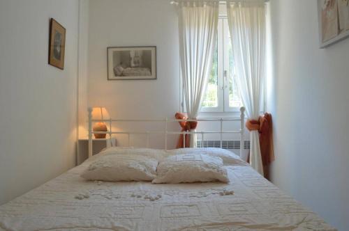 Ce lit se trouve dans une chambre blanche dotée d'une fenêtre. dans l'établissement Appart 3 pièces 4 couchages BANYULS SUR MER BN100-C601, à Banyuls-sur-Mer