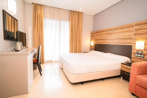 a hotel room with a bed and a desk at Magic Inn in Oropesa del Mar