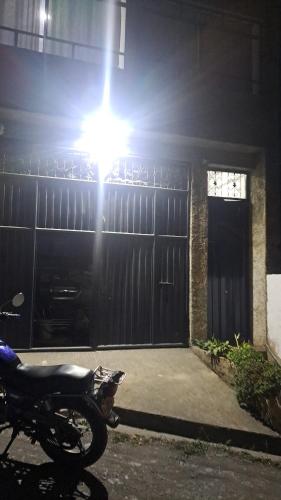 a motorcycle parked in front of a house at night at Apartamento Los Pinos in Macanal