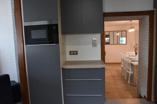 a kitchen with a refrigerator and a dining room at Le Nid des Cigognes avec terrace in Thionville