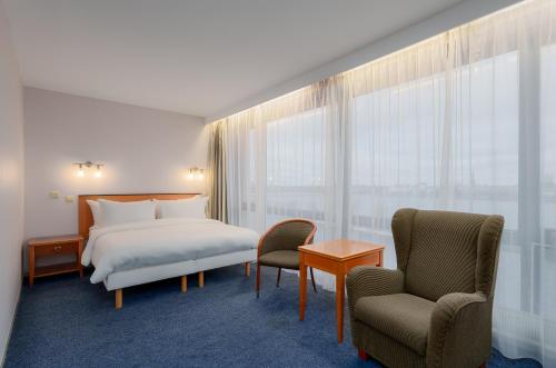 a hotel room with a bed and two chairs at Radisson Blu Hotel & Spa, Daugava Riga in Rīga