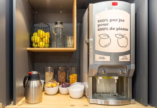 a coffee machine sitting on a counter with bowls of food at B&B HOTEL Nantes Aéroport in Bouguenais