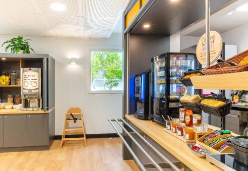 a bakery with a counter with bread and food at B&B HOTEL Nantes Aéroport in Bouguenais