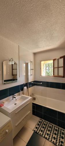 une salle de bain avec un lavabo, une baignoire et un miroir dans l'établissement Proche Mer YourHosteHelper, à Saint-Raphaël