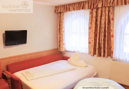 a small room with a bed and a television at Edelweißhof in Ischgl