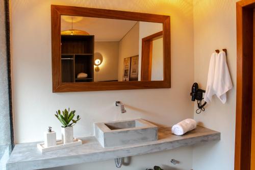 a bathroom with a sink and a mirror at Pousada K in Pirenópolis