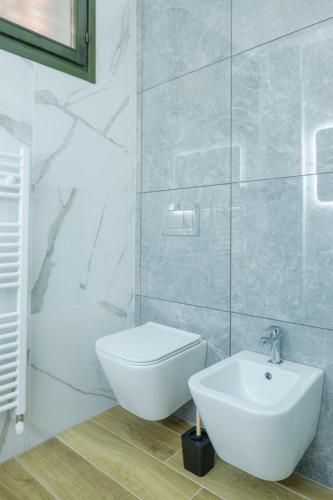 a white bathroom with a toilet and a sink at Casa Louise - appartamento Don Bedetti in Bologna