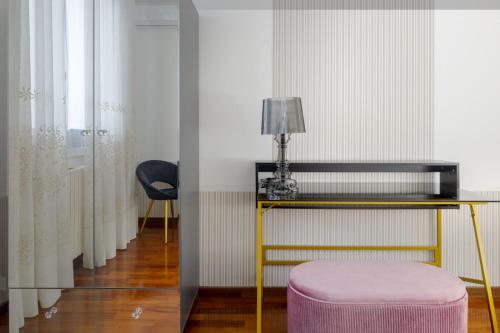 a room with a table and a chair and a stool at Casa Louise - appartamento Don Bedetti in Bologna