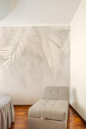 a living room with a couch and a palm tree mural at Casa Louise - appartamento Don Bedetti in Bologna