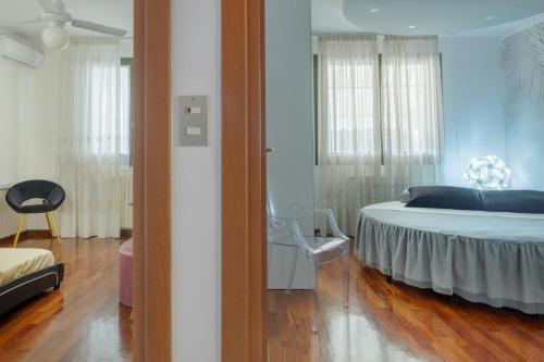 a bedroom with a bed and a chair in it at Casa Louise - appartamento Don Bedetti in Bologna