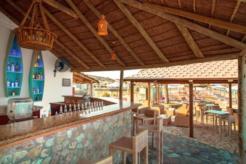 a restaurant with a bar with chairs and tables at The Cove Rotana Resort - Ras Al Khaimah in Ras al Khaimah