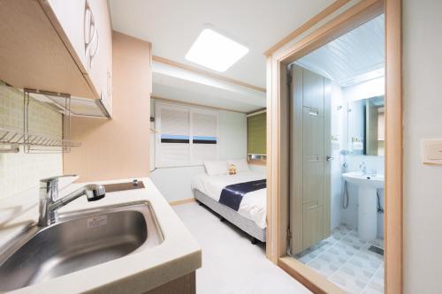 a bathroom with a sink and a bed in a room at Cave Myeongdong in Seoul