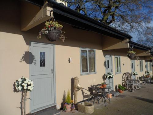 a house with a door and a table and chairs at The Stables - Deer Park Farm in Solihull