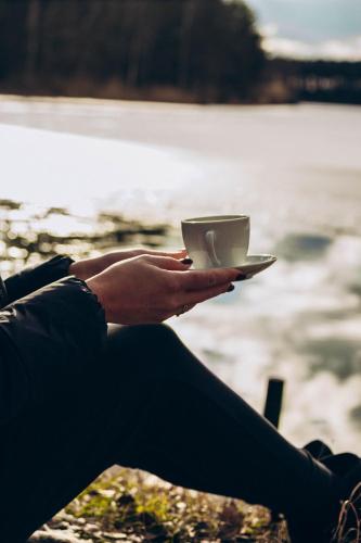 a person holding a cup of coffee in their hand at SergJuli Villa in Plavecký Štvrtok