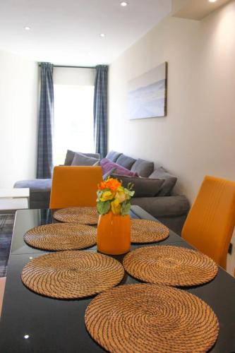 a table with chairs and a vase of flowers on it at 2 bed apartment clan house apartments in Galway