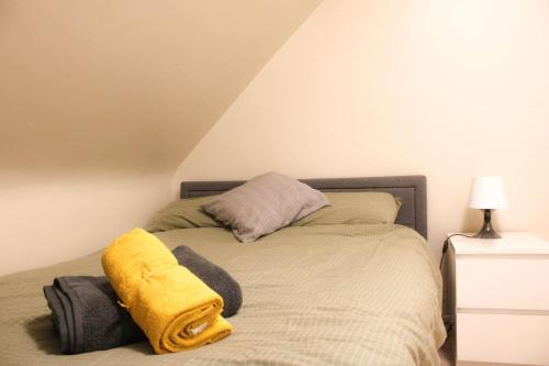 a bedroom with a bed with a yellow blanket on it at 2 bed apartment clan house apartments in Galway