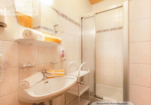 a white bathroom with a sink and a shower at Edelweißhof in Ischgl