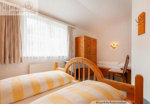 a bedroom with a bed and a table and a window at Edelweißhof in Ischgl