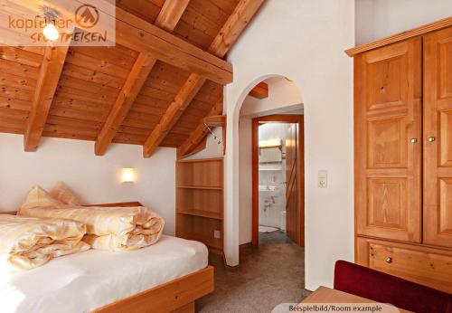 a bedroom with a bed and a wooden ceiling at Edelweißhof in Ischgl