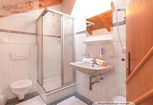 a bathroom with a shower and a sink and a toilet at Edelweißhof in Ischgl