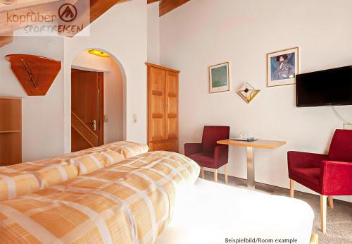 a hotel room with a bed and two chairs and a table at Edelweißhof in Ischgl