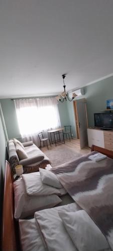 a room with three beds and a window at Panel Hause Kazincbarcika in Kazincbarcika