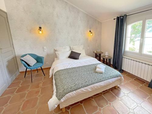une chambre avec un lit et une chaise bleue dans l'établissement Villa Suzanne - maison provençale, à Tourtour