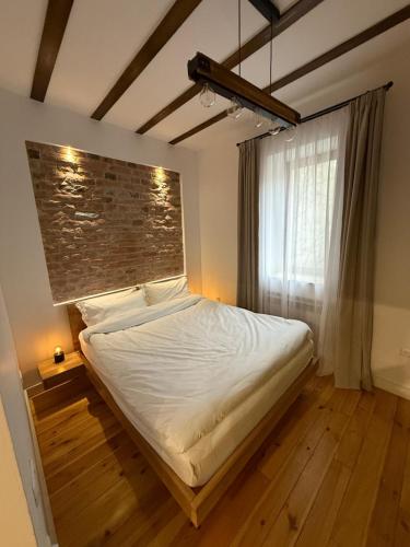 a bedroom with a large bed with a brick wall at MMA's Apartment - 1 min de Târgul de Crăciun Sibiu in Sibiu