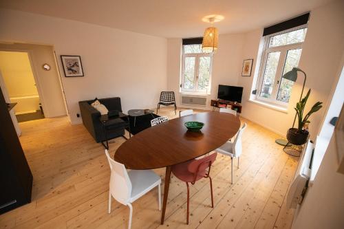 un salon avec une table et des chaises en bois dans l'établissement T3 lumineux au coeur de Moulins garage 2 places, à Lille