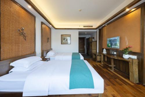 a bedroom with a large white bed and a desk at 云海酒店 in Zhangjiajie