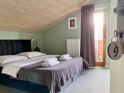 a bedroom with a large bed with towels on it at Gościniec Rajec in Rajcza