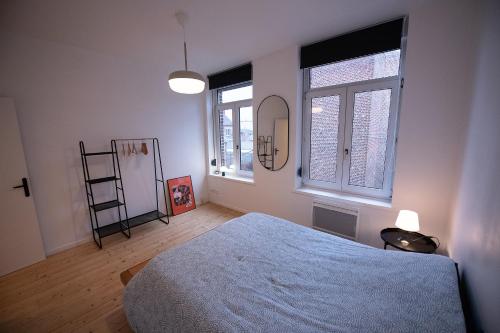 une chambre avec un lit et deux fenêtres dans l'établissement T3 lumineux au coeur de Moulins garage 2 places, à Lille
