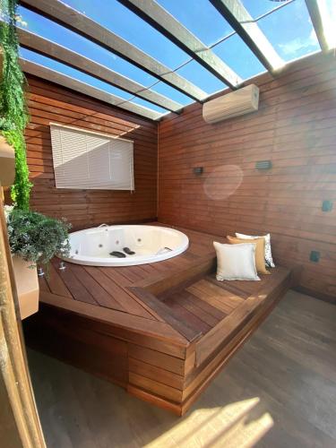 a large bathroom with a tub in the middle at Chalé Rústico Aconchegante com Hidro in Araranguá