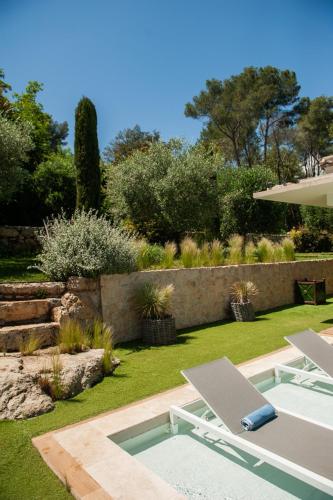 a pool with a table and a chair in a yard at la villa miel in Opio