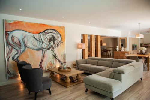 a living room with a painting of a horse on the wall at la villa miel in Opio