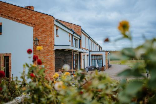 a brick building with flowers in front of it at Folwark Pszczew in Pszczew