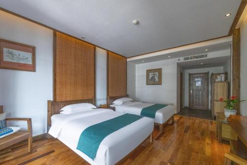 two beds in a large room with wooden floors at 云海酒店 in Zhangjiajie