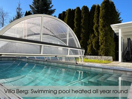 a swimming pool with a glass dome next to a house at Grand Villa Berg-Starnberg For Your Vacation, Retreat, Workshop, Corporate and Familys event in Berg am Starnberger See