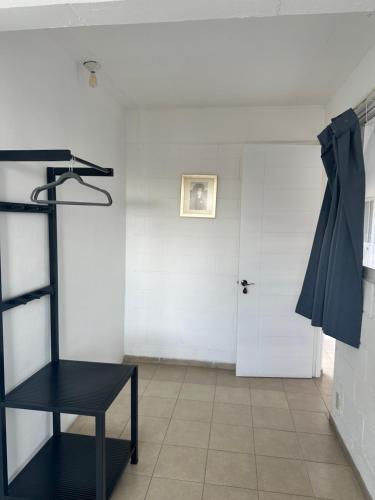 a room with a black chair and a door at Hotel El Romano in Ixtapan de la Sal